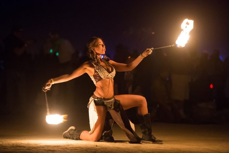 Künstlerin beim Tanzen mit Feuer nach dem Konsum einer die Sinne schärfenden Cannabissorte