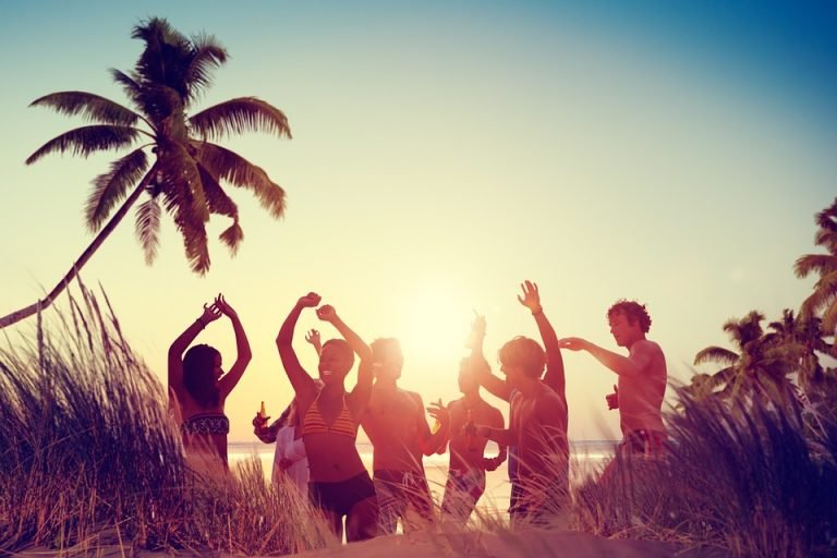 Am Strand feiernde junge Erwachsene nach dem Konsum einer erhebenden Cannabissorte